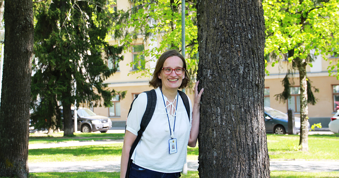 Eija Ahlholm reppu selässä puistossa.